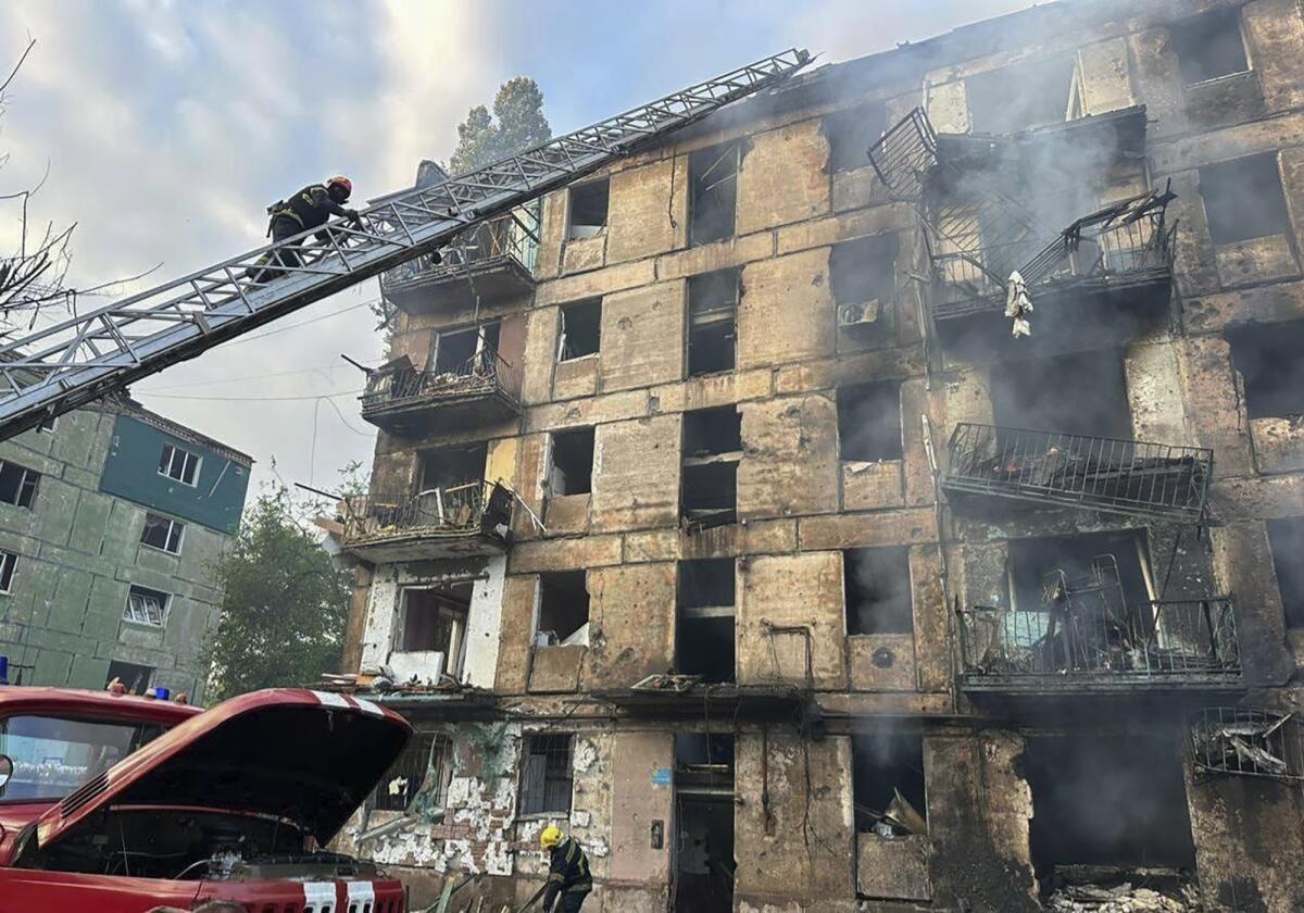 Firefighters putting out a blaze in an apartment building hit by missiles
