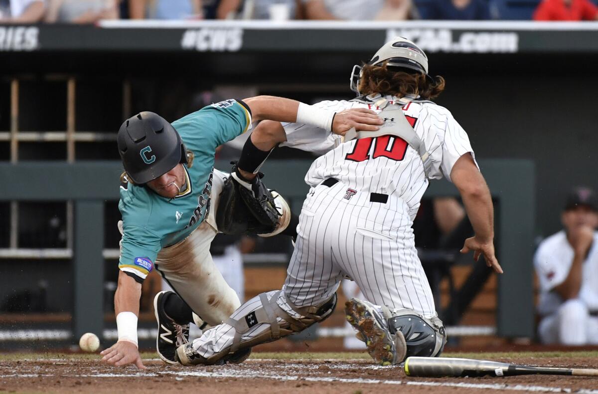 Coastal Carolina's Zach Remillard reaches to score around Texas Tech catcher Tyler Floyd (16) as the ball gets away at home plate in the third inning.