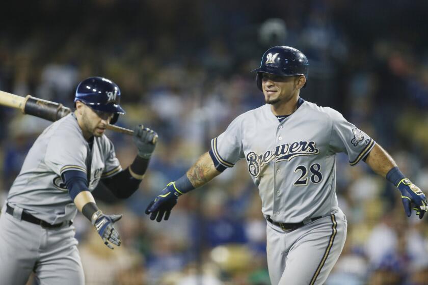Brewers left fielder Gerardo Parra is congratulated by teammate Ryan Braun after hitting a home run against the Dodgers in the seventh inning Saturday night.