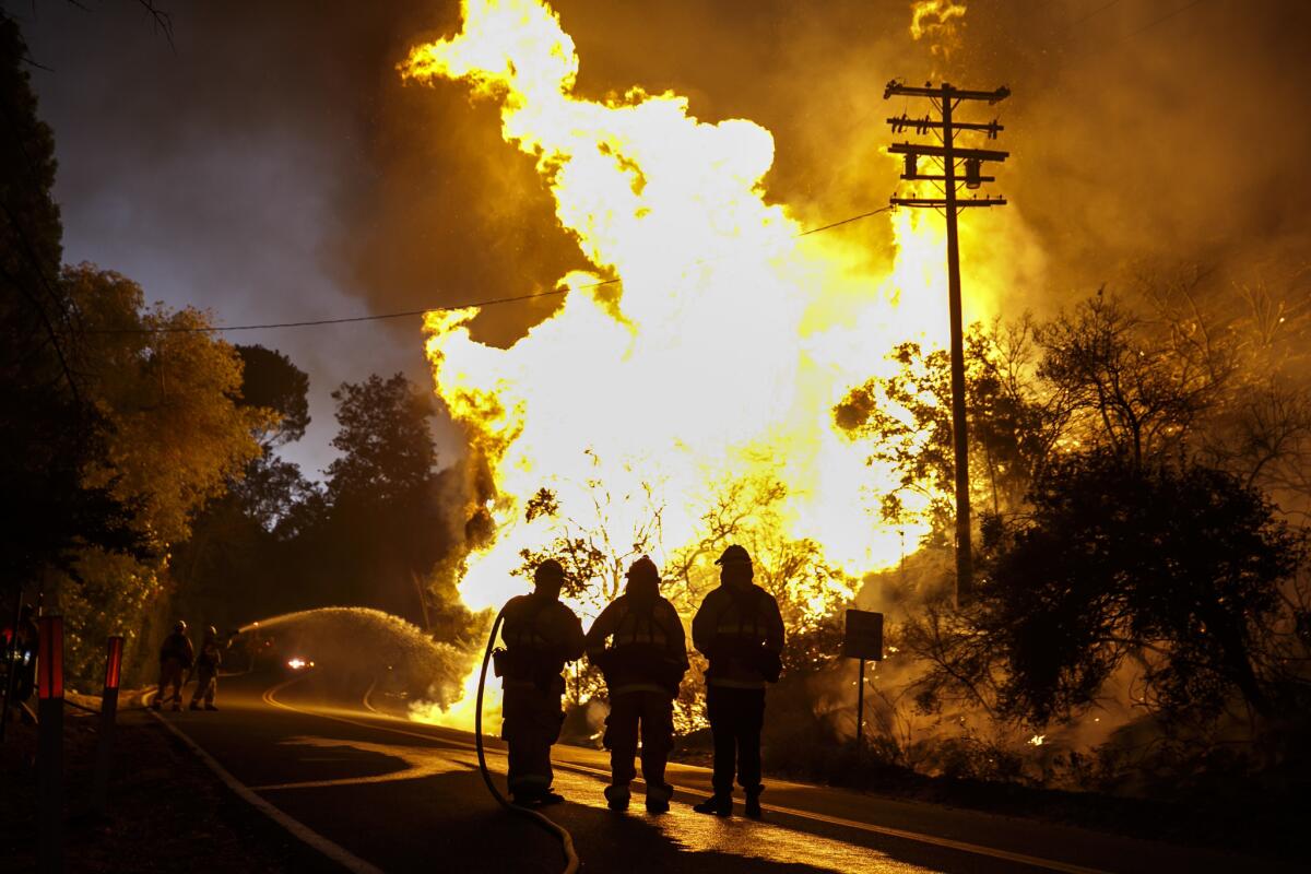 Firefighters monitor the Blue Cut fire traveling on the side of Lytle Creek Road.