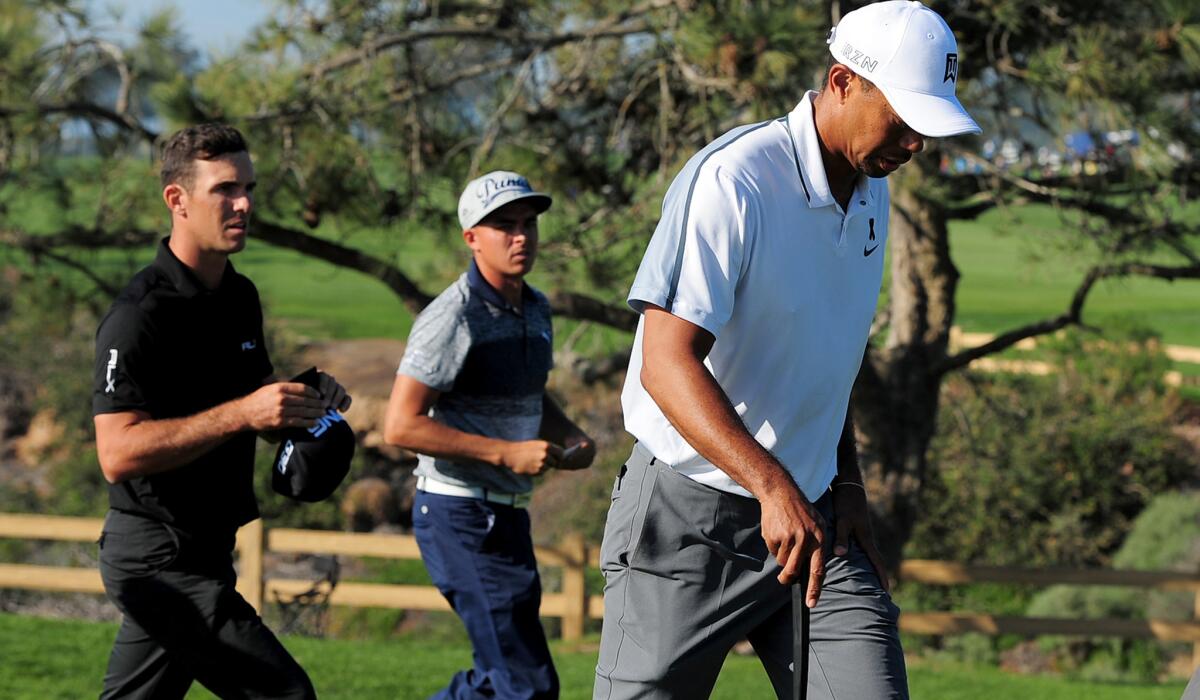 Tiger Woods walks off Torrey Pine Golf Course after withdrawing from the Farmers Insurance Open because of a back injury on Thursday.