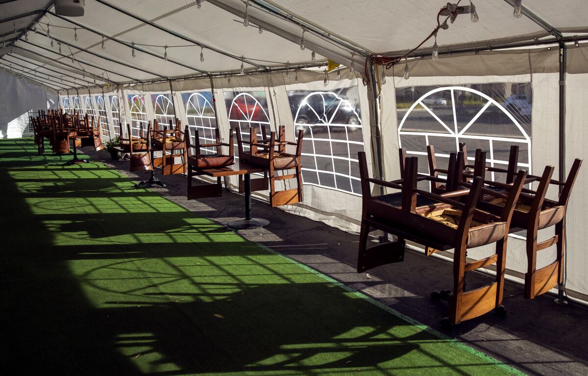 Stacked empty chairs in a tent with artificial grass