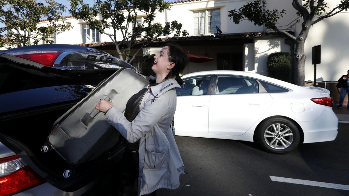 Elena Markusic lifts her heavy luggage into the trunk of an at Union Station in Los Angeles. Transportation officials are considering a tax on Uber and Lyft rides in Los Angeles County.
