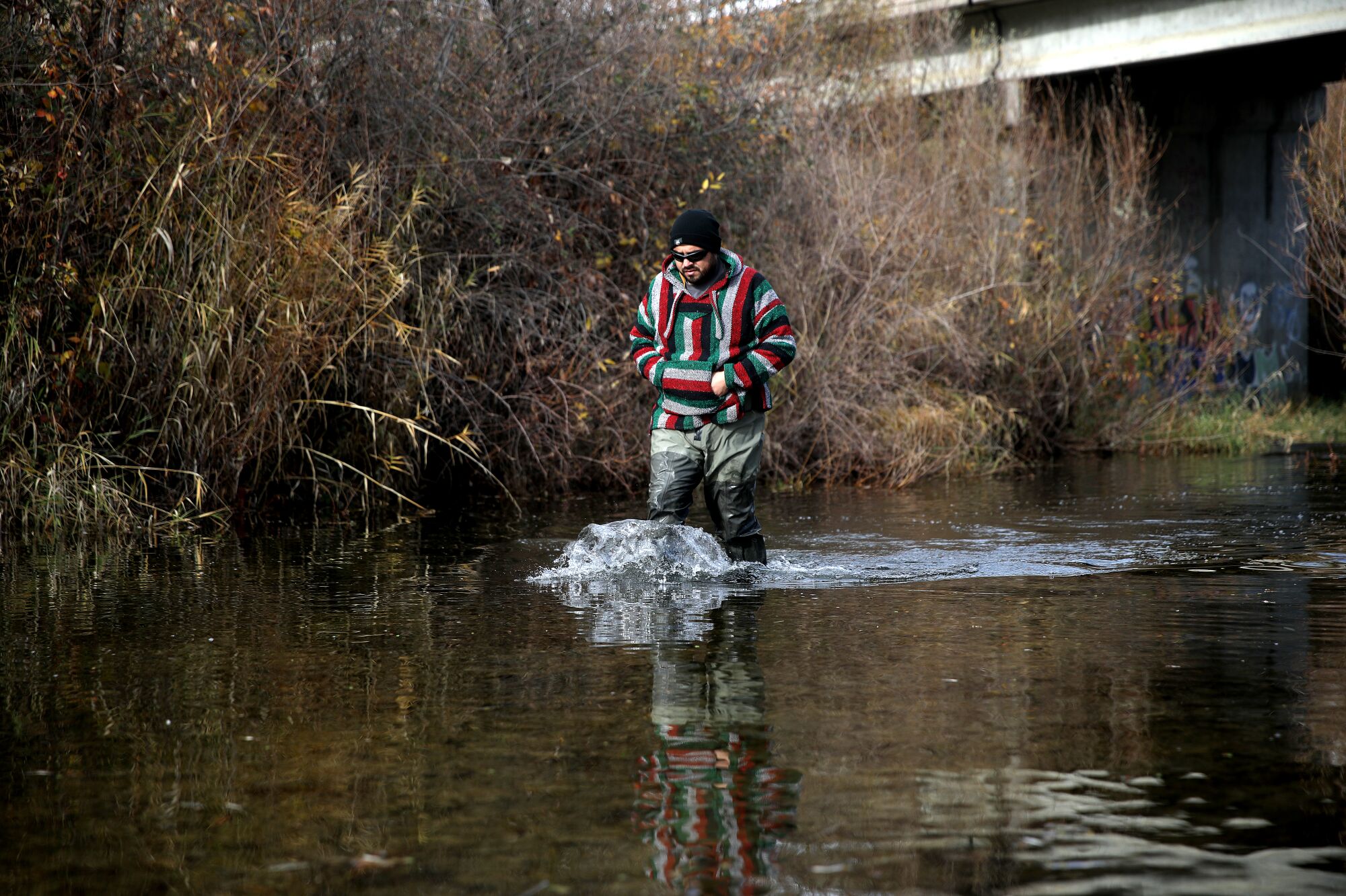 Luis Santana wades in water in Middle Creek. 