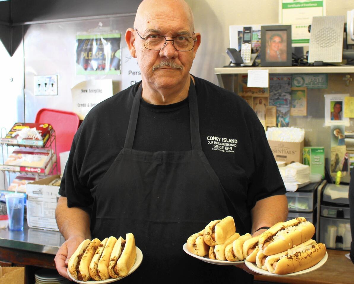 Server Dennis Parker, affectionately known as "Tiny," balances a large order of properly topped wieners at the Famous Coney Island Wiener Stand, a Fort Wayne staple since 1914.