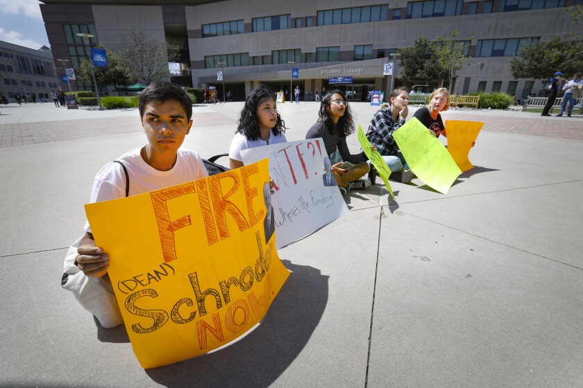 Cal State University San Marcos students are seen demonstrating against former CSUSM dean Michael Schroder.