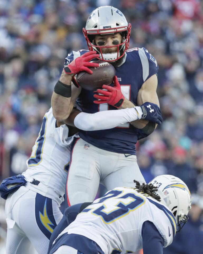 New England Patriots receiver Julian Edelman hauls in a 28-yard pass over Chargers defenders Rayshawn Jenkins and Michael Davis during a first quarter scoring drive in the NFL AFC Divisional Playoff at Gillette Stadium.