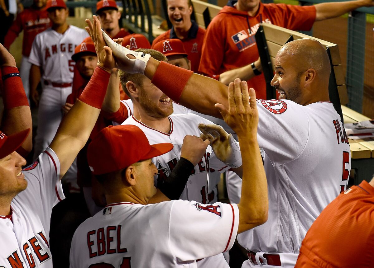 Albert Pujols celebrates with his teammates after a first-inning home run Monday against Cincinnati.