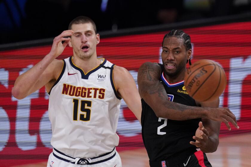 The Clippers' Kawhi Leonard passes in front of the Nuggets' Nikola Jokic on Sept. 5, 2020.