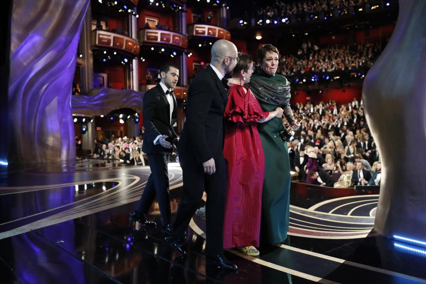 Olivia Colman wins the best actress award for "The Favourite" and walks off stage with Frances McDormand and Sam Rockwell at the 91st Academy Awards on Sunday.