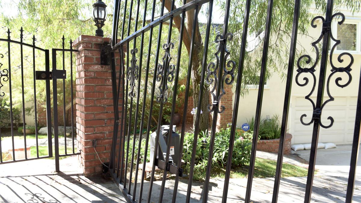 A black metal gate that blocks Anton Yelchin's sloping driveway appears bent and damaged on June 19.