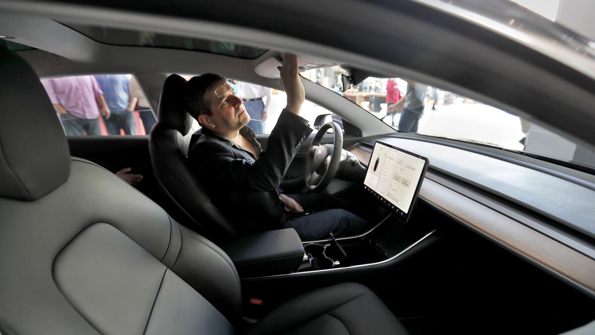Jay Corson of Sherman Oaks explores the Tesla Model 3 in Century City last month.