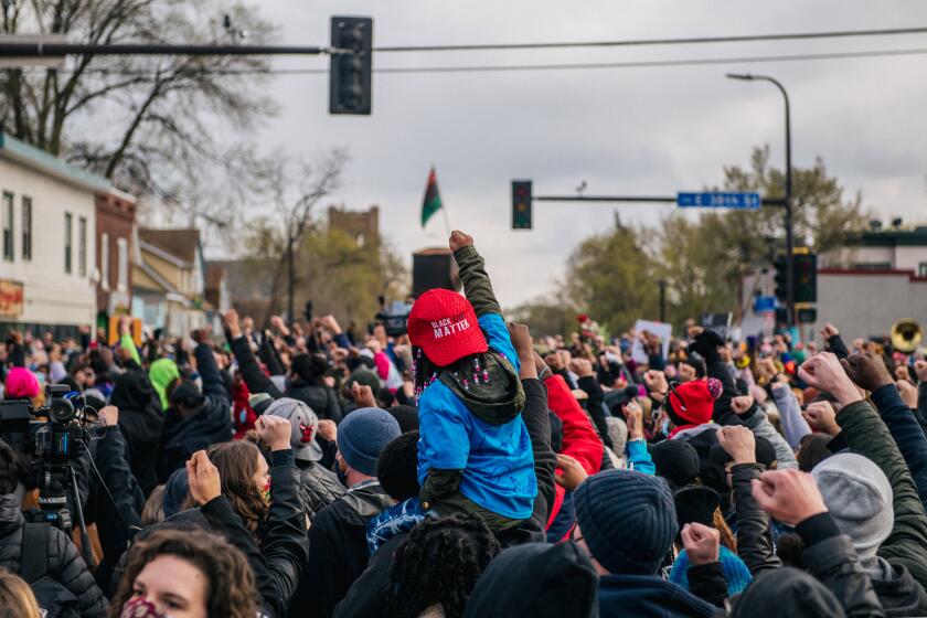 MINNEAPOLIS, MN - APRIL 20: A child sits atop an adult's shoulders during a gathering at the intersection of 38th Street and Chicago Avenue following the verdict in the Derek Chauvin trial on April 20, 2021 in Minneapolis, Minnesota. The former Minneapolis police officer was found guilty today on all three charges he faced in the death of George Floyd last May. (Photo by Brandon Bell/Getty Images)