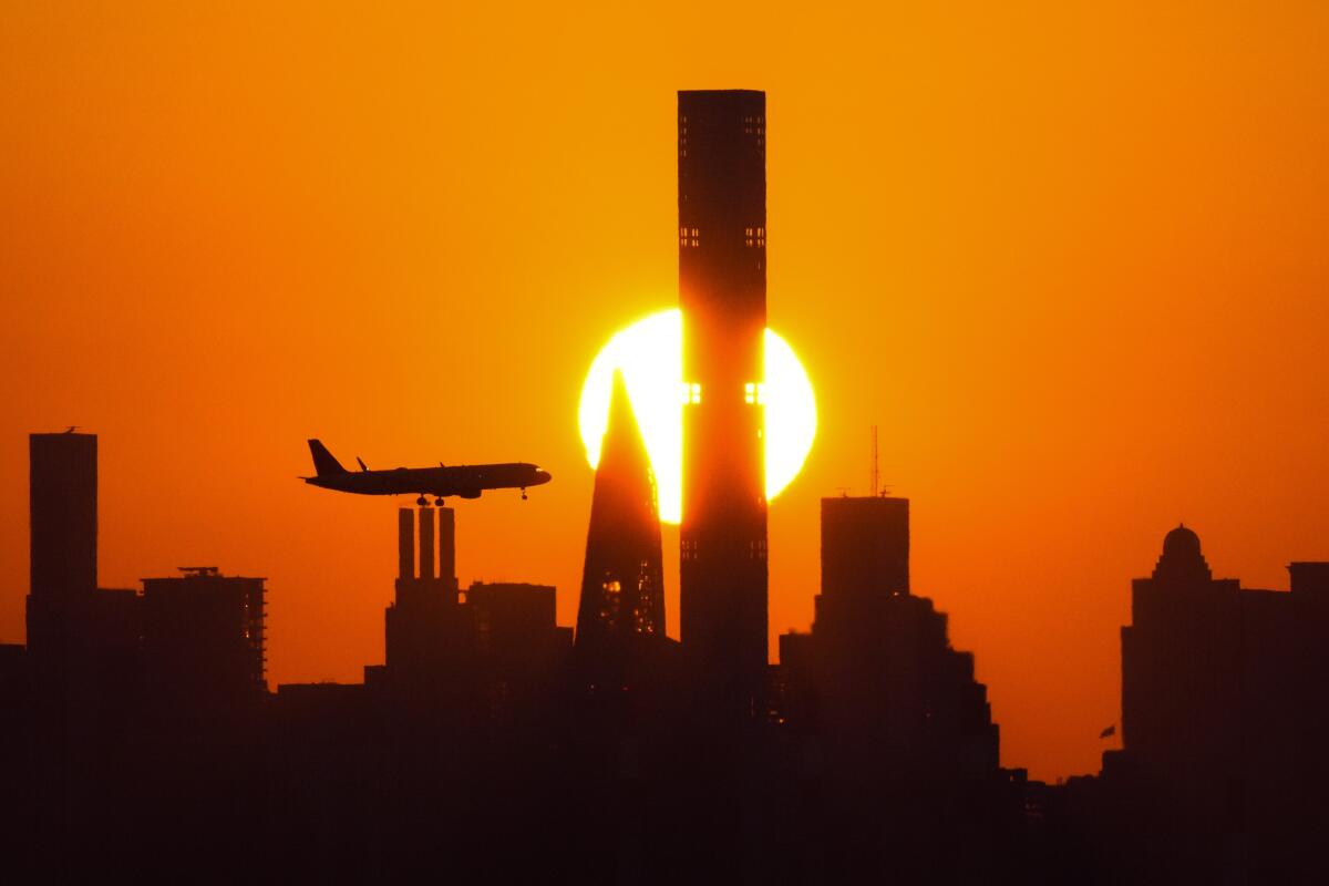 ARCHIVO- Se pone el sol detrs de los rascacielos de Nueva York y un avin se aproxima al Aeropuerto LaGuardia, 6 de setiembre de 2023, en Nueva York. Comienzan los viajes de vacaciones en autopistas, trenes y aviones en Estados Unidos. (AP Foto/Frank Franklin II, File)
