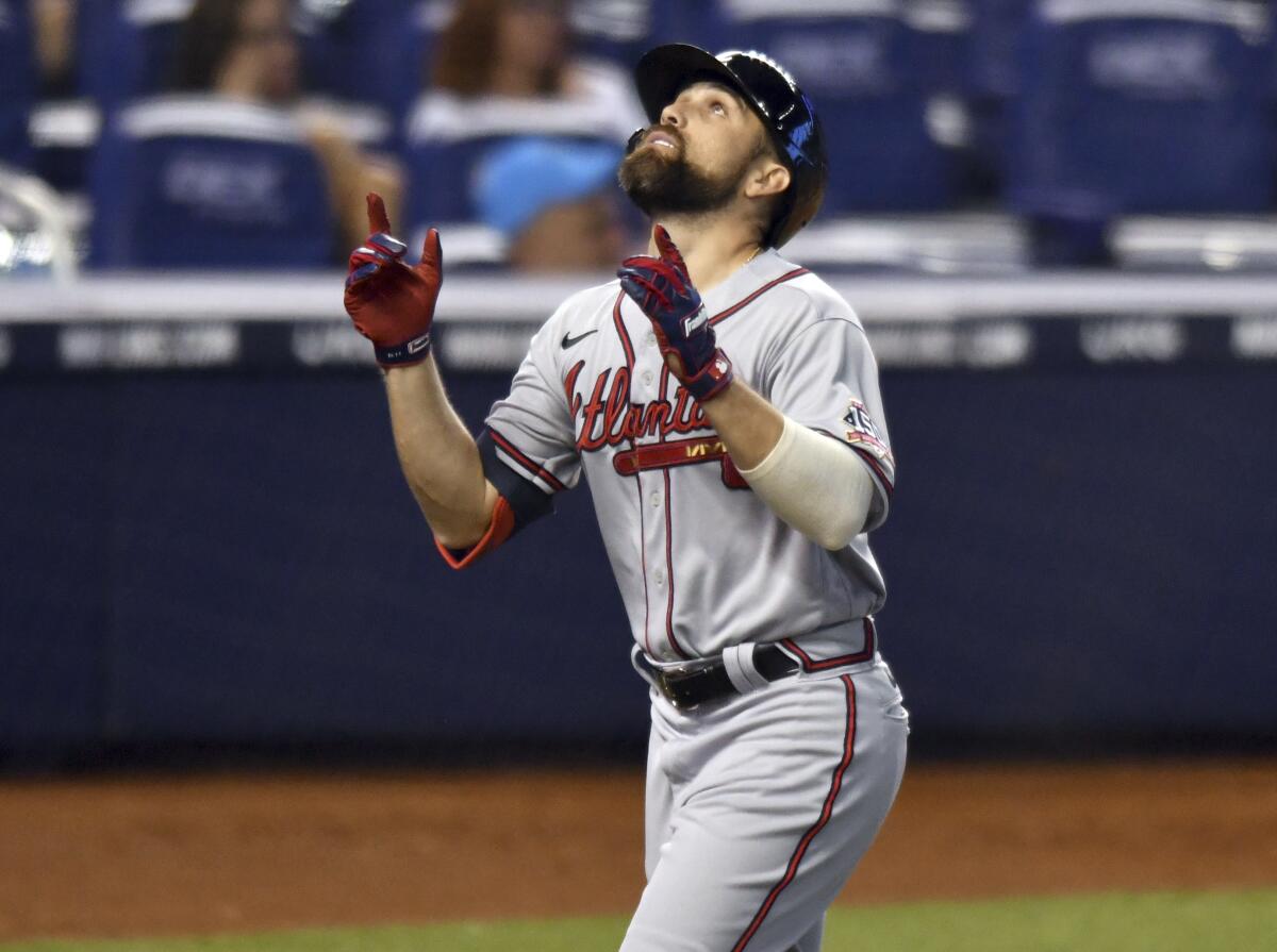 Atlanta Braves' Ender Inciarte (11) looks up as he crosses home plate after hitting a home run against the Miami Marlins during the sixth inning of a baseball game, Sunday, June 13, 2021, in Miami. (AP Photo/Jim Rassol)