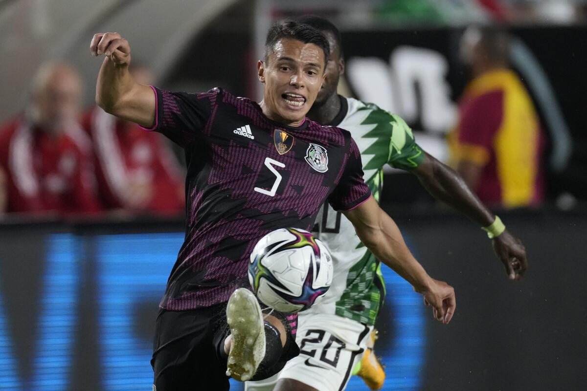 Mexico defender Osvaldo Rodriguez controls the ball ahead of Nigeria defender Emmanuel Oluesi during the first half.