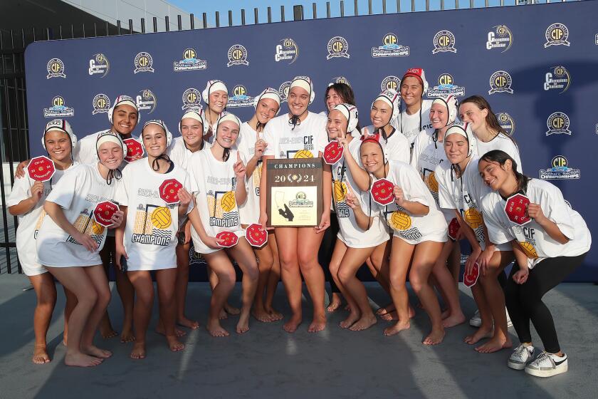 The Corina del Mar girls' water polo team poses for a picture after winning the the CIF Southern Section, Division 1 title match against J-Serra at Mt. San Antonio College on Saturday.