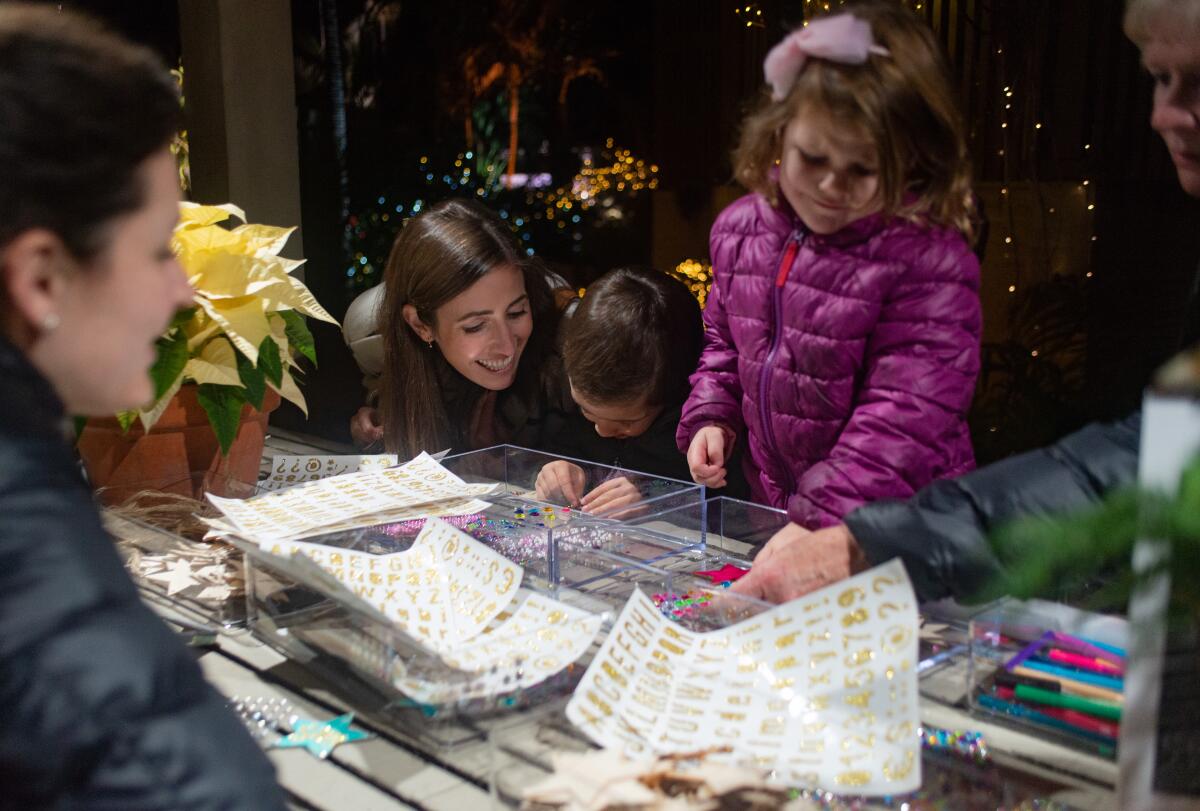 Parents help children craft homemade ornaments during the Nights of 1,000 Lights at Sherman Gardens & Library.