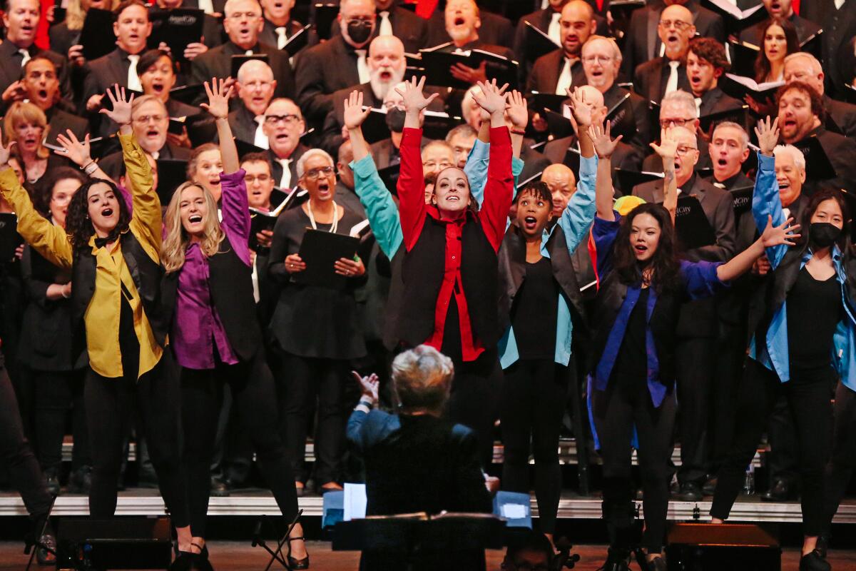 Members of a choir with their arms outstretched.