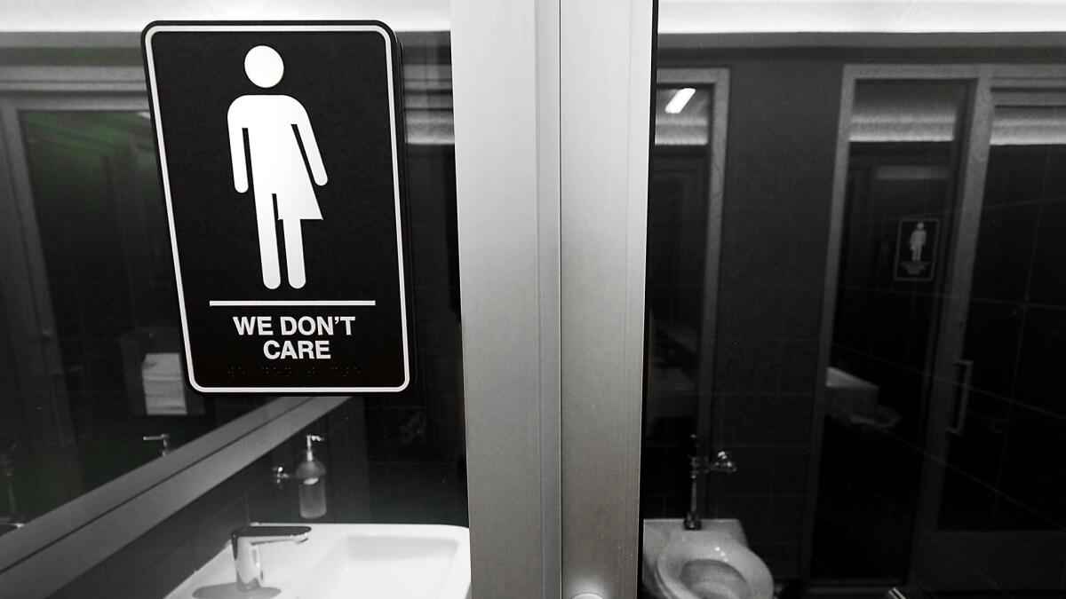 Gender-neutral signs posted in public restrooms in Durham's 21C Museum Hotel.
