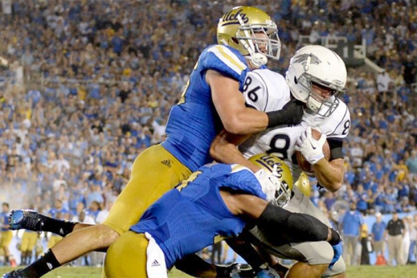 UCLA's Jordan Zumwalt, left, and Anthony Barr, center, tackle Nevada's Kolby Arendse on Aug. 31, 2013.