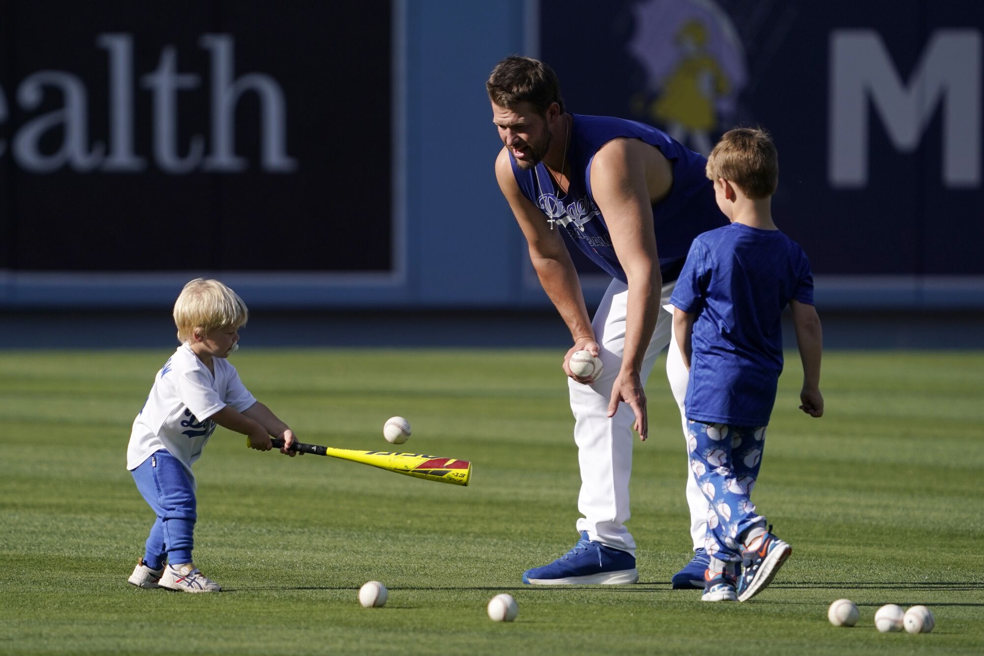 Los Angeles Dodgers pitcher Clayton Kershaw pitches to his son Cooper, left, as his other son Charley watches