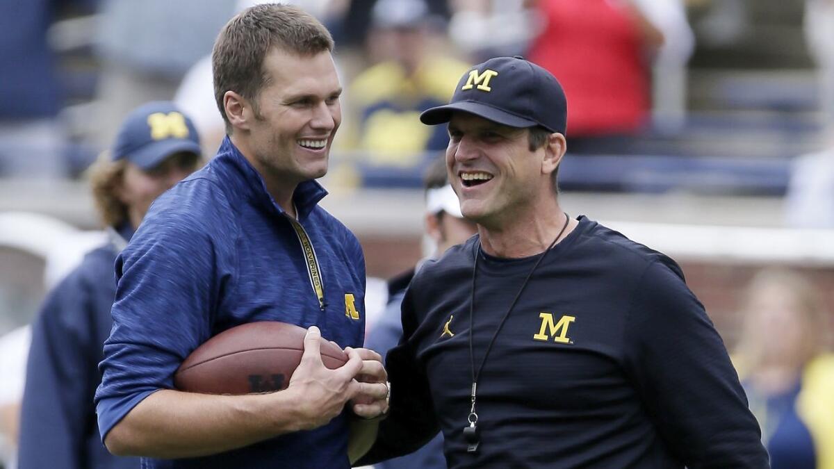 New England Patriots quarterback Tom Brady, left, on the field with Michigan coach Jim Harbaugh before the Wolverines' game against Colorado on Sept. 17, 2016.