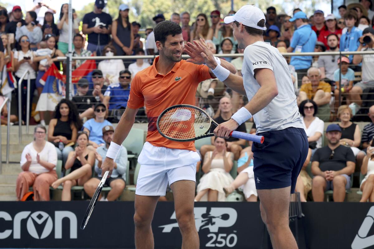 Serbia's Novak Djokovic reacts with Canada's Vasek Pospisil during their doubles match against Tomislav Brkic of Bosnia and Ecuador's Gonzalo Escobar during their Round of 32 match at the Adelaide International Tennis tournament in Adelaide, Australia, Monday, Jan. 2, 2023. (AP Photo/Kelly Barnes)