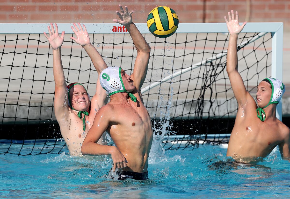 Costa Mesa's Dylan Rothen (9) blocks a shot by Edison in a nonleague boys' water polo game in Huntington Beach on Tuesday.