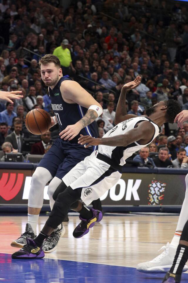 Mavericks forward Luka Doncic (77) fouls Clippers guard Patrick Beverley (21) during the first half of a game Jan. 21.