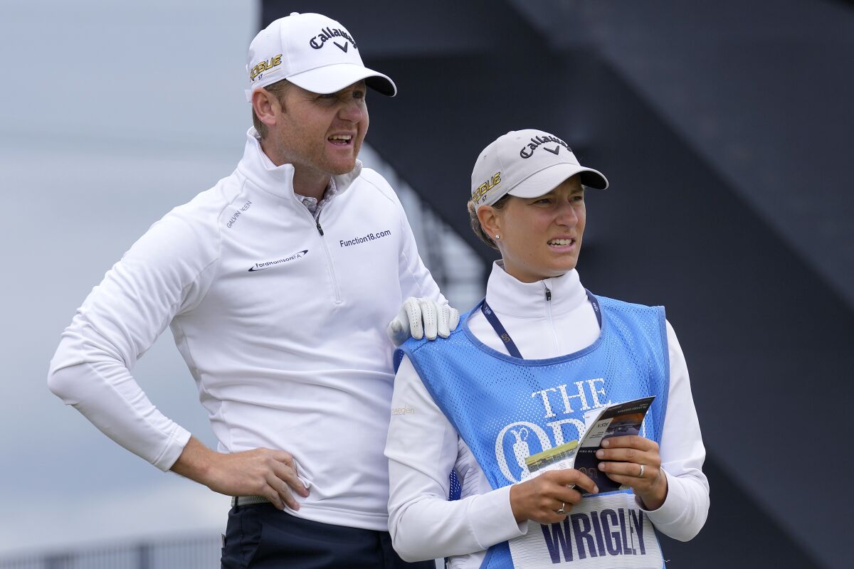 Alex Wrigley and his wife, Johanna Gustavsson, stand on the Old Course at St. Andrews during a British Open practice round.