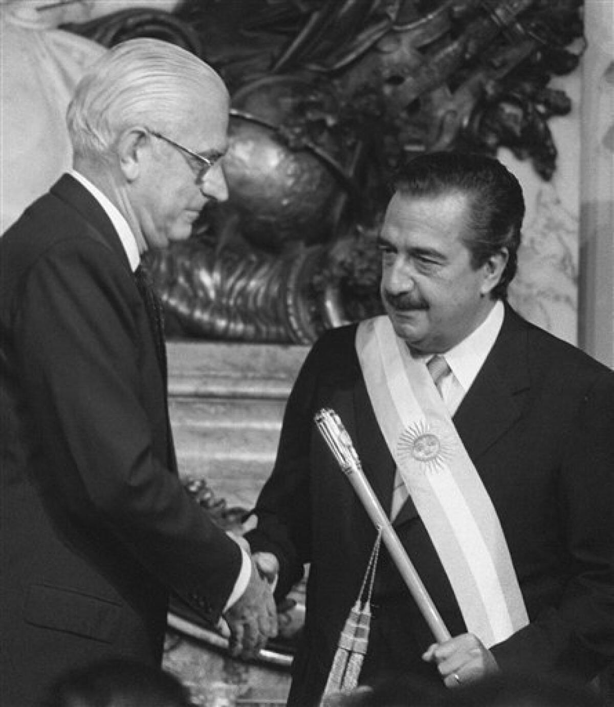 Former Argentina's President Raul Alfonsin, right, shakes hands with outgoing dictator Gen. Reynaldo Bignone in this Dec. 10, 1983 file photo, during Alfonsin�s inauguration ceremony. Alfonsin, the first democratically elected president following the end of the 1976-1983 military dictatorship, died at age 82 Tuesday, March 31, 2009, after suffering from lung cancer and pneumonia. (AP Photo/Eduardo Di Baia)