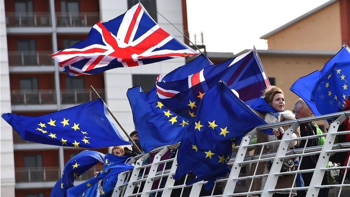 Anti-Brexit activists fly EU and Union flags from the Millennium Bridge in Newcastle, England on March 15.