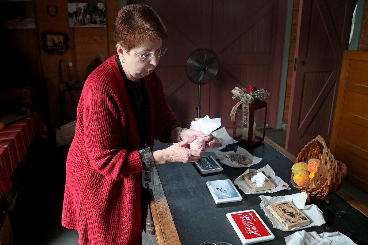 Jane K. Newell demonstrates how Valencia oranges were packaged for Christmas. 