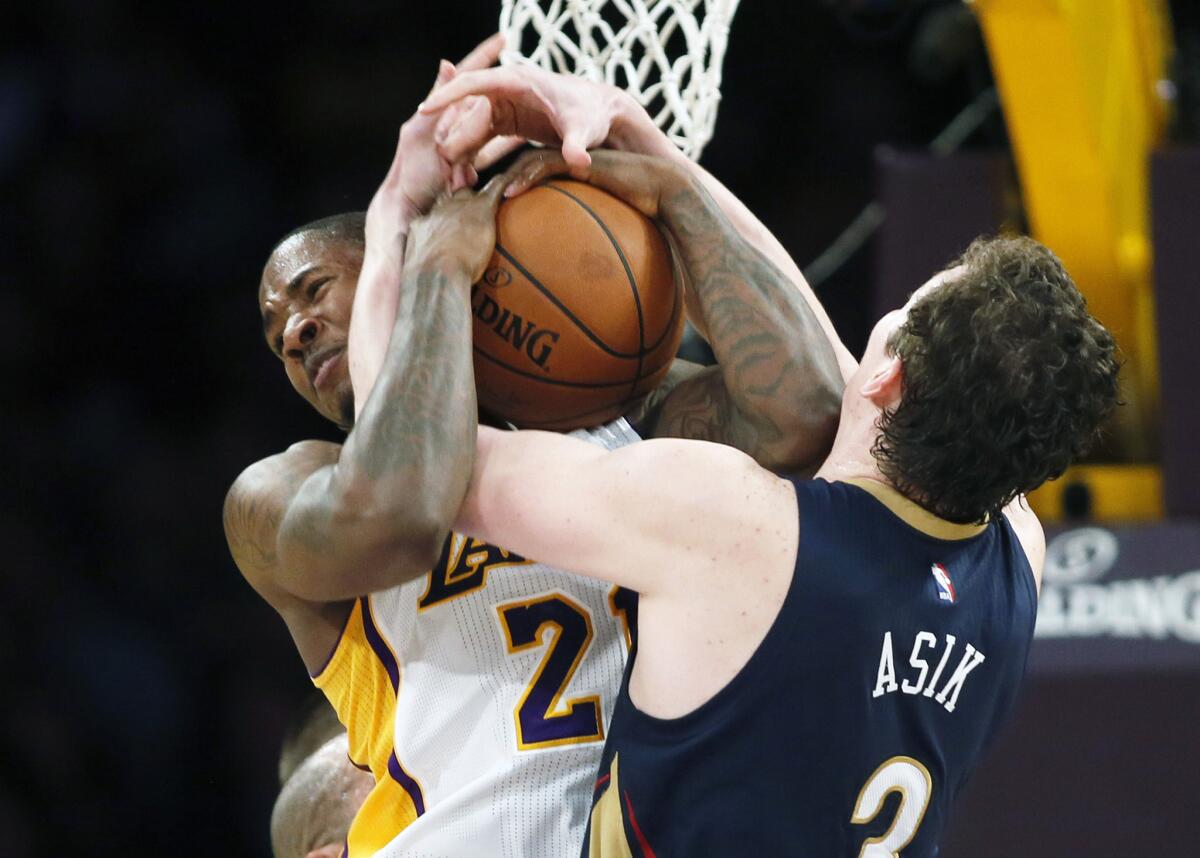 Lakers forward Ed Davis battles Pelicans center Omer Asik for a rebound in the first half Sunday night.