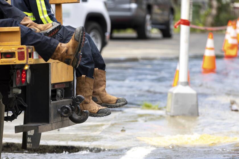 Trabajadores llegan a una tubería principal de agua dañada en Joseph E. Boone Boulevard y James P. Brawley Drive en Atlanta, el viernes 31 de mayo de 2024. (Arvin Temkar/Atlanta Journal-Constitution via AP)