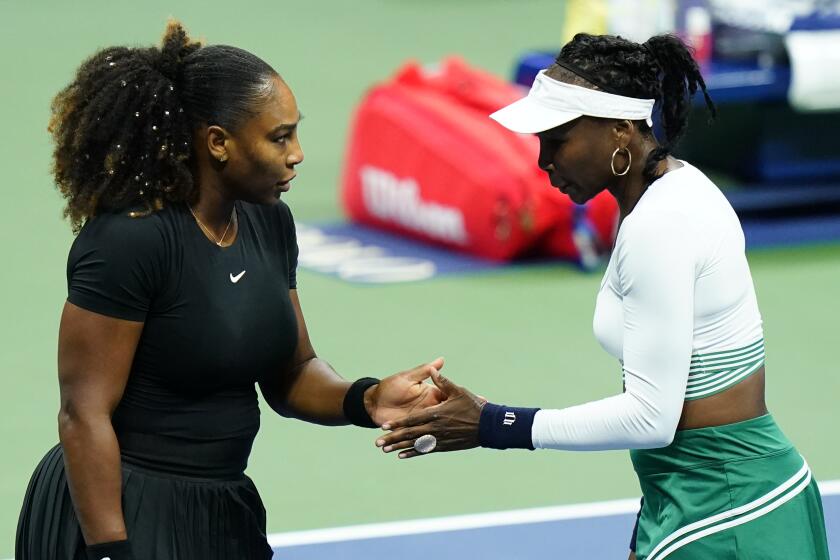 Serena Williams, left, and Venus Williams, of the United States, celebrate during their first-round doubles match.