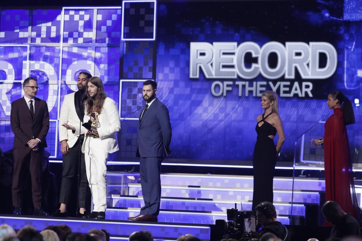 Derek Ali y Ludwig Goransson aceptan el premio a la Grabación del Año por "This is America" en el estrado del Grammy.