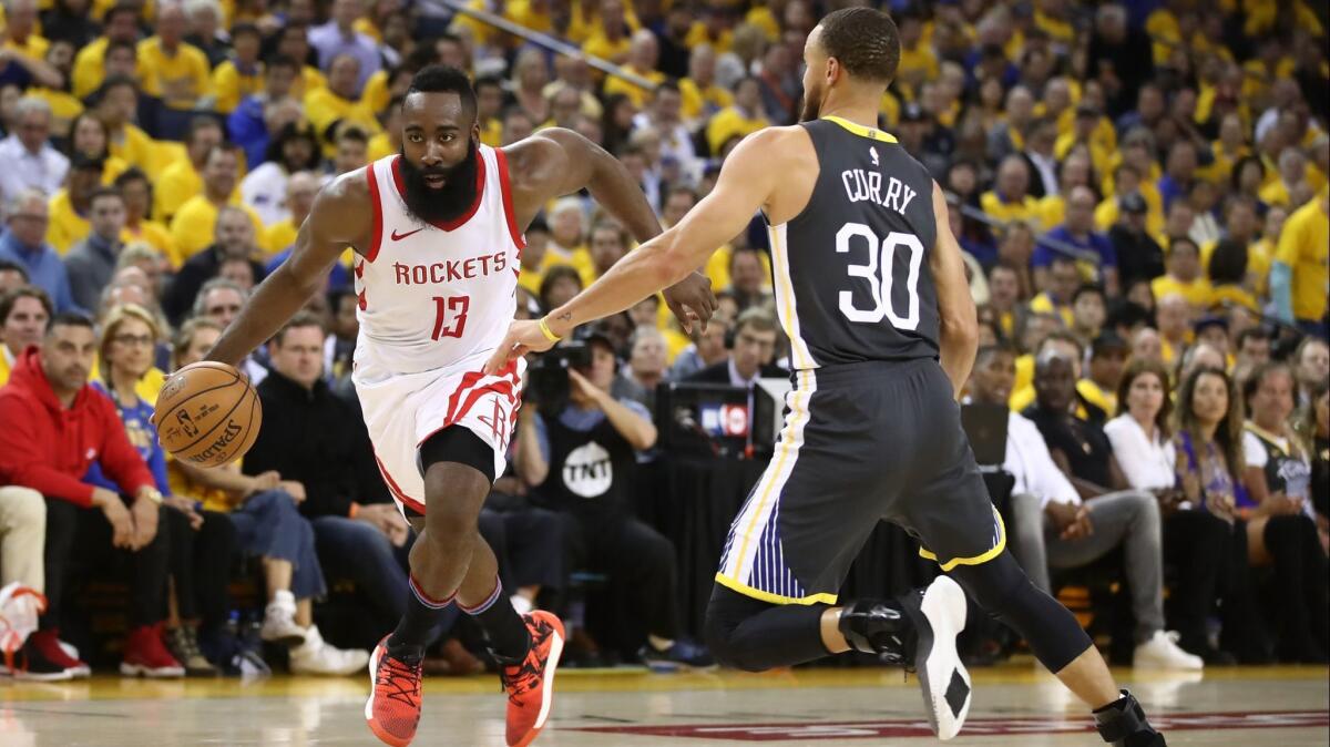 Houston Rockets' James Harden (13) drives with the ball against Golden State Warriors' Stephen Curry (30) during Game Four of the Western Conference finals on Tuesday.