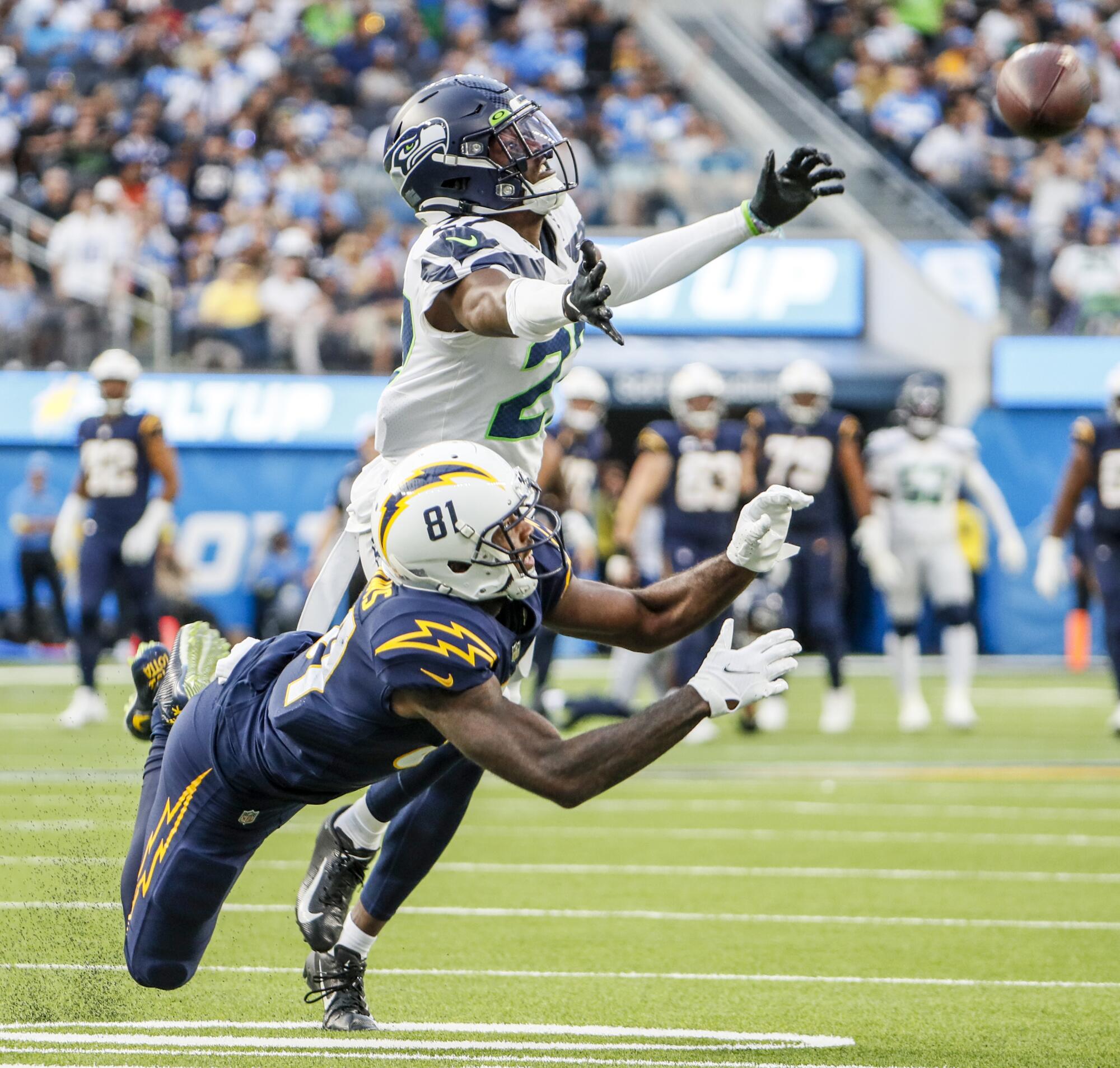 Seattle Seahawks cornerback Tariq Woolen (27) defends a pass intended for Los Angeles Chargers wide receiver Mike Williams.