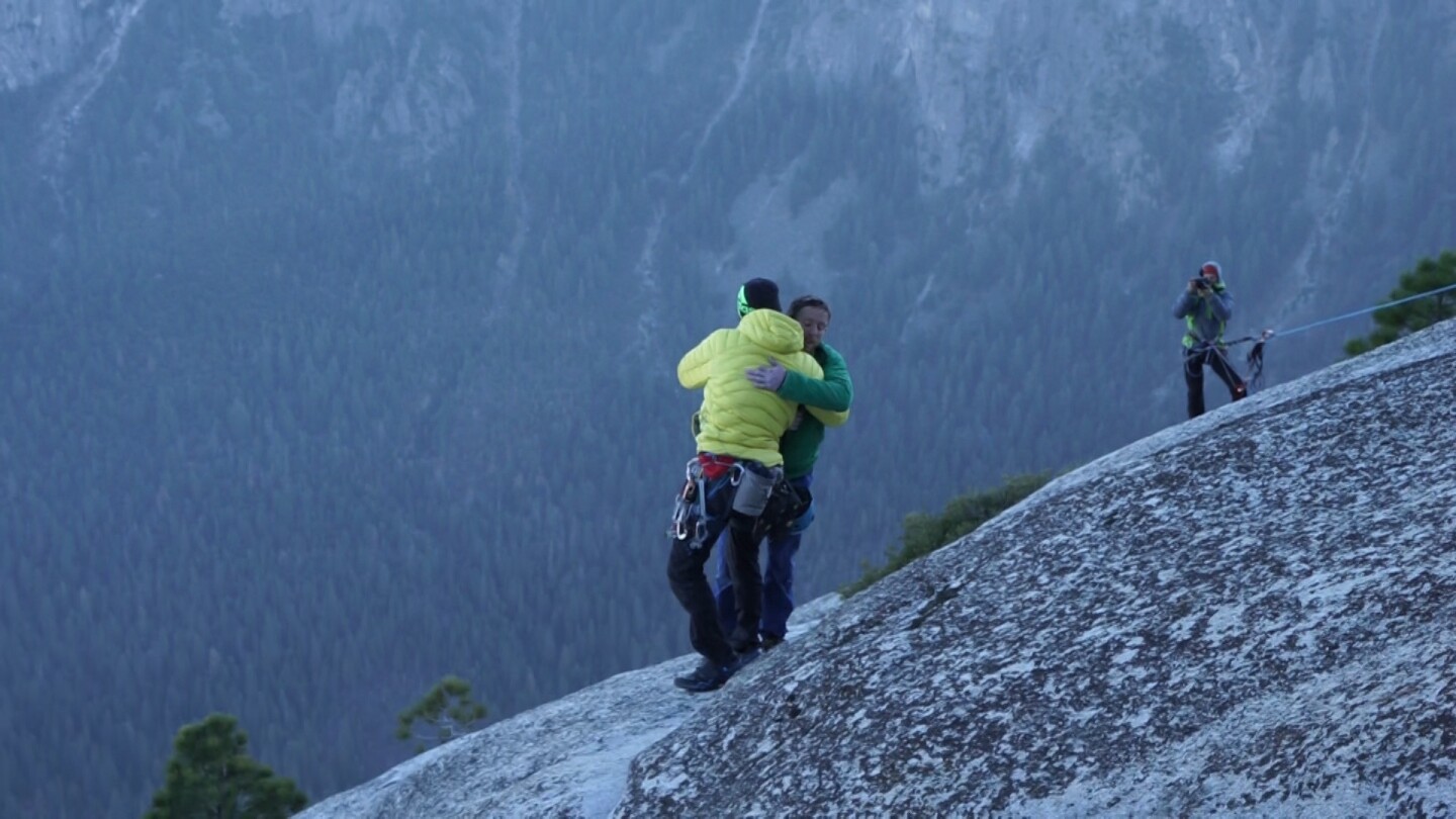 Kevin Jorgeson, in yellow, and Tommy Caldwell, in green hug at the summit after completing their free climb of the Dawn Wall at El Capitan in Yosemite National Park on Jan. 14.