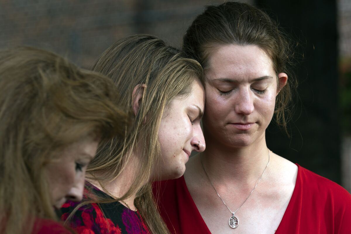 Summerleigh Winters Geimer, center, and her sister, Montana Winters Geimer, right, daughters of Wendi Winters, a community beat reporter who was killed in the Capital Gazette newsroom shooting, react during a news conference following the sentencing verdict of Jarrod W. Ramos, Tuesday, Sept. 28, 2021, in Annapolis, Md. Ramos was sentenced to more than five life terms without the possibility of parole, according to prosecutors. (AP Photo/Jose Luis Magana)