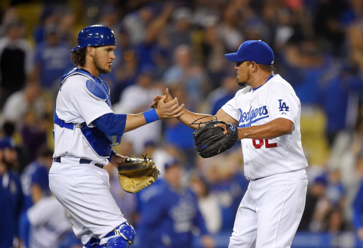 Relief pitcher Joel Peralta celebrates with catcher Yasmani Grandal after recording his third save of the year in the Dodgers' 6-3 victory over the Colorado Rockies on April 18.