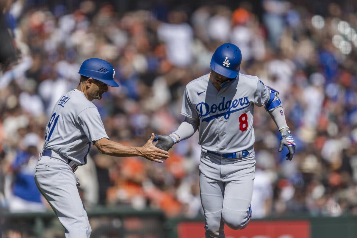 Dodgers' Kiké Hernández is congratulated by coach Dino Ebel after homering against the San Francisco Giants on Oct. 1, 2023.