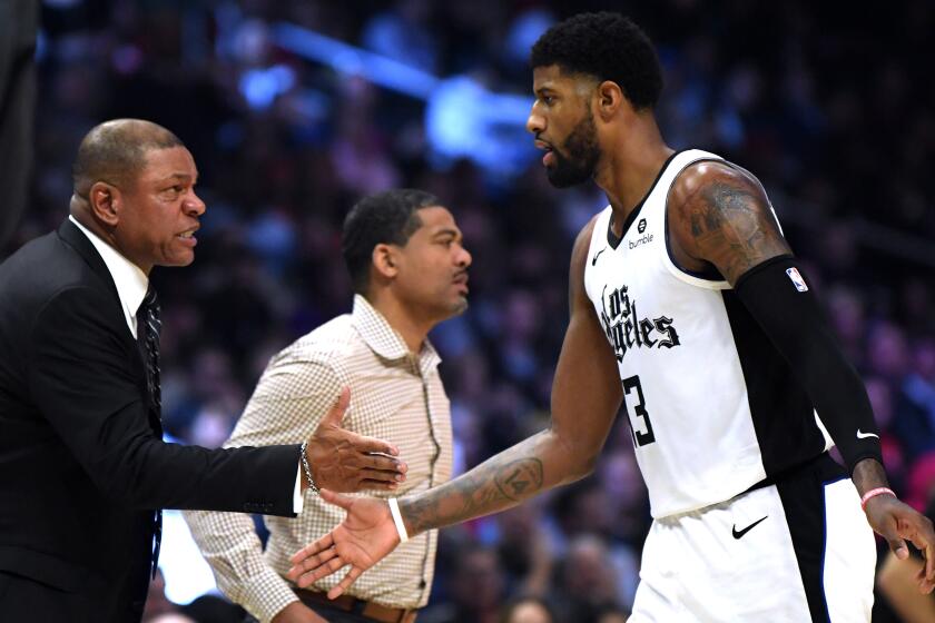 Clippers coach Doc Rivers congratulates forward Paul George after he made a three-point shot against the Rockets earlier this season.