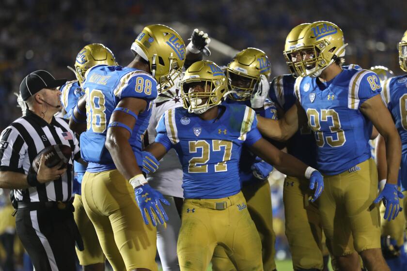 LOS ANGELES, CALIFORNIA - OCTOBER 26: Mike Martinez #88, David Priebe #83 congratulate Joshua Kelley #27 of the UCLA Bruins after he scored a rushing touchdown during the second half of a game against the Arizona State Sun Devils on October 26, 2019 in Los Angeles, California. (Photo by Sean M. Haffey/Getty Images) ** OUTS - ELSENT, FPG, CM - OUTS * NM, PH, VA if sourced by CT, LA or MoD **