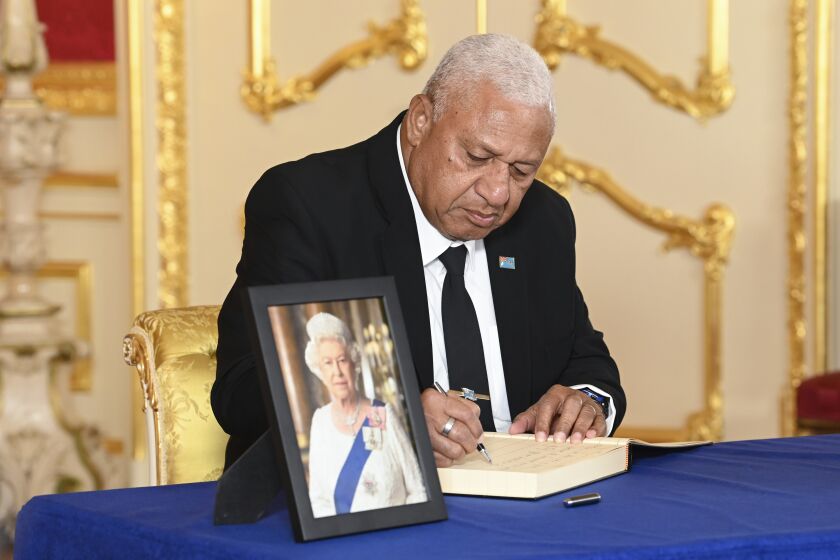 Prime Minister of Fiji, Josaia Voreqe Bainimarama signs a book of condolence at Lancaster House, London, Sunday, Sept. 18, 2022, following the death of Queen Elizabeth II. ( Jonathan Hordle/Pool Photo via AP)