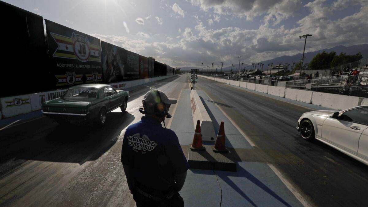 A pair of cars jump off the starting line during a drag race at the Irwindale Speedway.