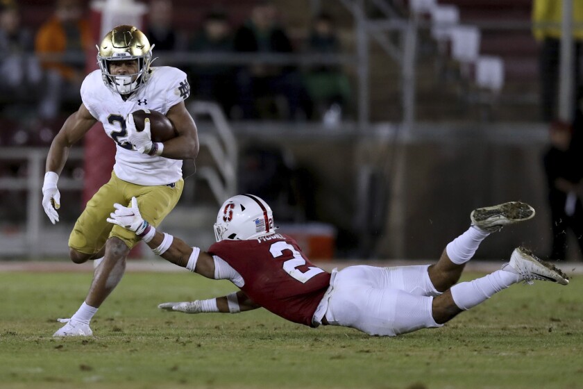 Notre Dame's Chris Tyree (25) runs around Stanford's Jonathan McGill (2) during the second half of an NCAA college football game in Stanford, Calif., Saturday, Nov. 27, 2021. (AP Photo/Jed Jacobsohn)