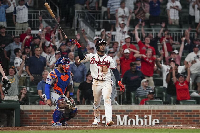CORRECTS TO THREE-RUN HOME RUN, NOT TWO-RUN - Atlanta Braves second baseman Ozzie Albies (1) reacts after hitting a game-winning, three-run home run, next to New York Mets catcher Omar Narvaez (2) during the 10th inning of a baseball game Thursday, June 8, 2023, in Atlanta. (AP Photo/John Bazemore)